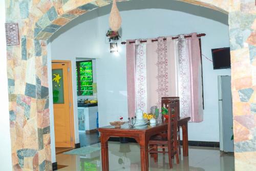 a dining room with a table and a room with a window at Bandara House in Midigama