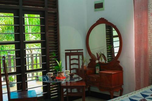 una stanza con specchio, tavolo e sedie di Bandara House a Midigama East