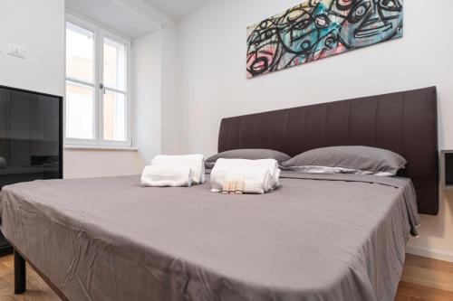 a bedroom with a large bed with two pillows on it at Hurban Apartments Venezian in Trieste