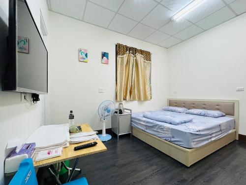 a room with a bed and a desk in a room at Hello in Fangliao