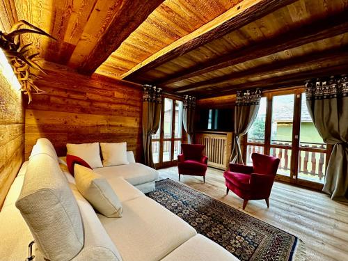 Alpine Escape 3 في بورميو: غرفة معيشة مع أريكة بيضاء وكراسي حمراء