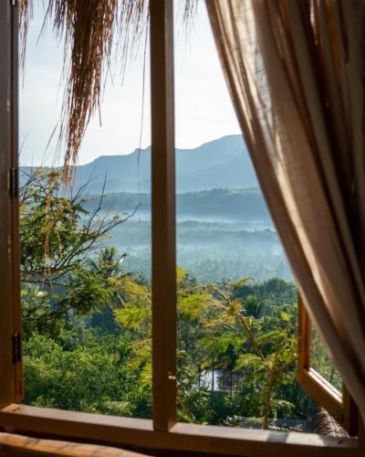 an open window with a view of the jungle at The Mudhouse Marayoor in Munnar