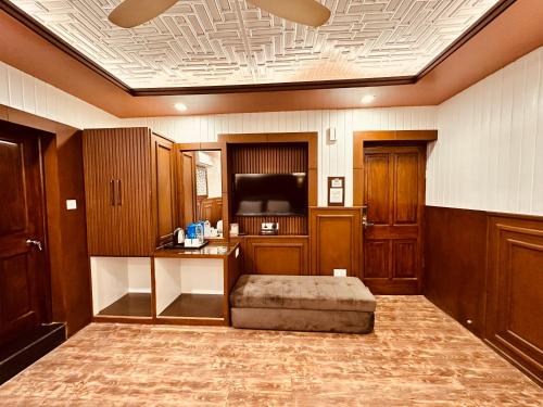 - un salon avec une télévision et un canapé dans l'établissement Walisons Hotel, à Srinagar