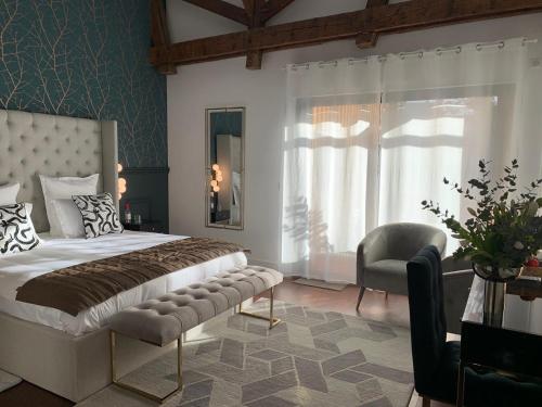 ボルドーにあるLa Cabane D'Ambroiseのベッドルーム1室(ベッド1台、椅子、窓付)