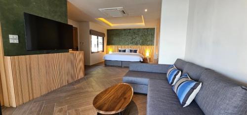 a living room with a couch and a bed at Punnpreeda Beach Resort - SHA Plus Certified in Bang Rak Beach