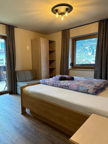 Un dormitorio con una cama grande y una ventana en Apartment Bischofer, en Aschau