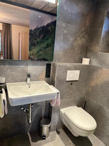 ein Badezimmer mit einem Waschbecken, einem WC und einem Spiegel in der Unterkunft Apartment Bischofer in Aschau