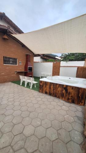 a patio with two white tables and a building at Casa com Jacuzzi aquecida praia do Lazaro in Ubatuba