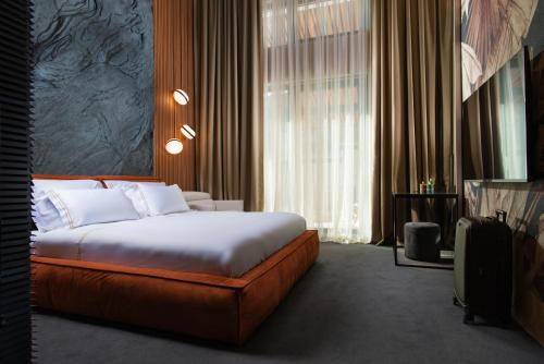 サパレヴァ・バニャにあるAlpine Bell Villaのベッドと大きな窓が備わるホテルルームです。