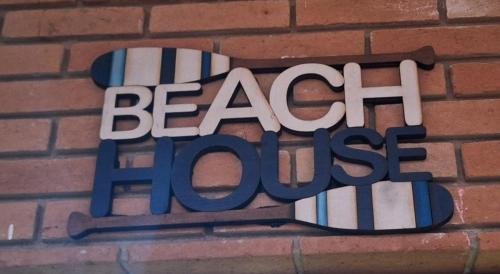 a sign on a brick wall with the words beach house at Casa com Jacuzzi aquecida praia do Lazaro in Ubatuba