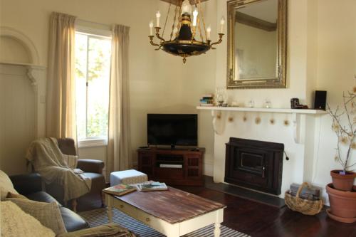 a living room with a fireplace and a television at Bickley Valley Cottage in Bickley