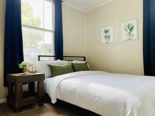 a bedroom with a white bed and a window at Abode à la Mode / Centrally Located 2BR/1BA Home in Evansville