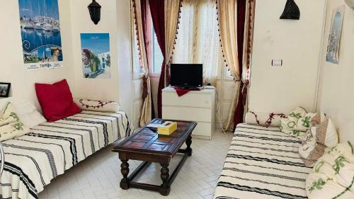 ein Wohnzimmer mit einem Sofa und einem Couchtisch in der Unterkunft Bungalow S+1 au port de Kantaoui, Sousse. Avec balcon offrant une panorama envoûtant in Sousse