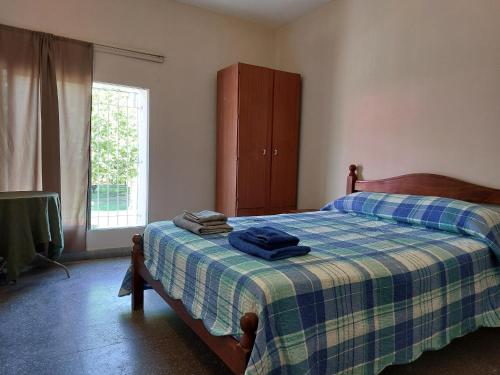 a bedroom with a bed with a plaid blanket at Departamento del Parque in Santa Rosa