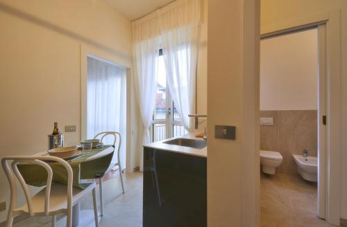 a bathroom with a sink and a table and a toilet at Verde Acqua two Apartments in Lecco