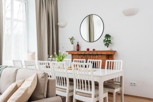 uma sala de jantar branca com uma mesa e cadeiras brancas em Modern Centrally Located Apartment na Cracóvia