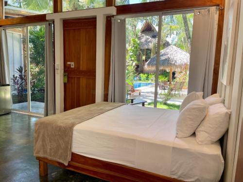 a bedroom with a large bed and a large window at Fuego Lodge in Santa Teresa Beach