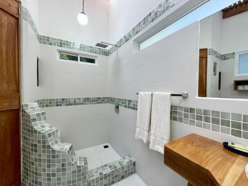 a bathroom with a tub and a sink at Fuego Lodge in Santa Teresa Beach