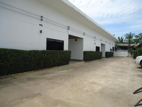 a large white building with bushes in front of it at Pine Home in Krabi town