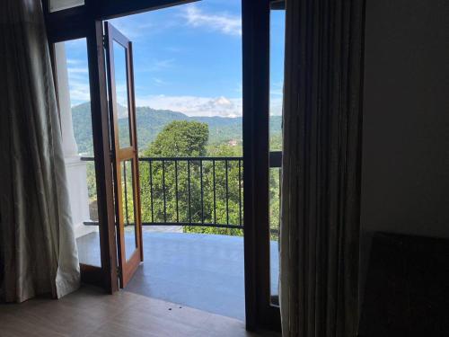 an open door to a balcony with a view at Gannoru Hatana Villa in Kandy