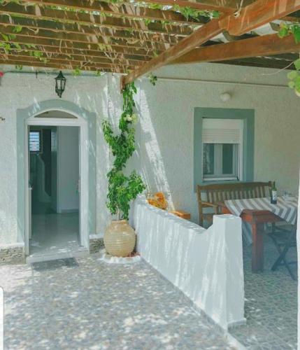 a porch of a house with a vase with a plant at Avgerinou Studios in Paliochori