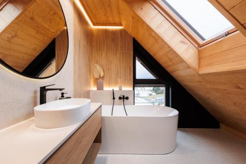 a bathroom with two sinks and a tub and a window at Stylchyn Park - Czorsztyn Exclusive - by Upstairs in Kluszkowce