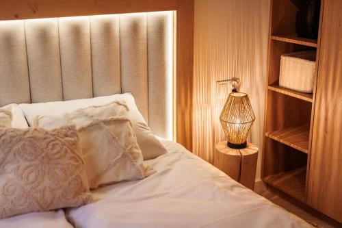 a bed with a pillow and a lamp in a room at Stylchyn Park - Czorsztyn Exclusive - by Upstairs in Kluszkowce