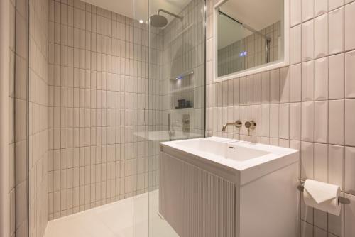 a white bathroom with a sink and a mirror at Hausd - Soho in London