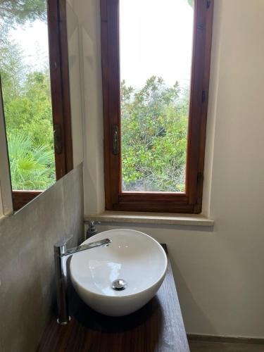 a white sink in a bathroom with a window at VILLA IL TUFO in Siena