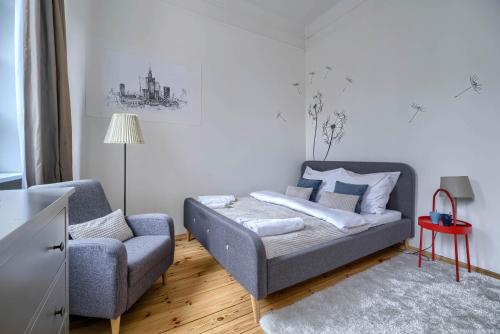 ein Wohnzimmer mit einem Sofa und einem Stuhl in der Unterkunft Corolla Apartments Nowy Świat 52 Stare Miasto in Warschau