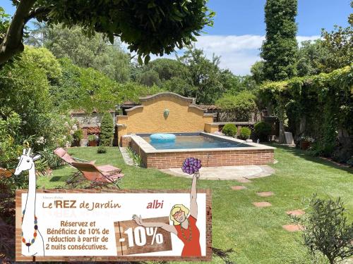 - un panneau dans une cour avec une piscine dans l'établissement Le Rez de Jardin Albi, à Albi