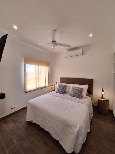 sypialnia z białym łóżkiem i oknem w obiekcie Los Carpinchos: Duplex w mieście Federación