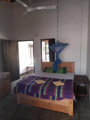 Un dormitorio con una cama con una lámpara azul. en School Keen Kite Surf en Kalpitiya