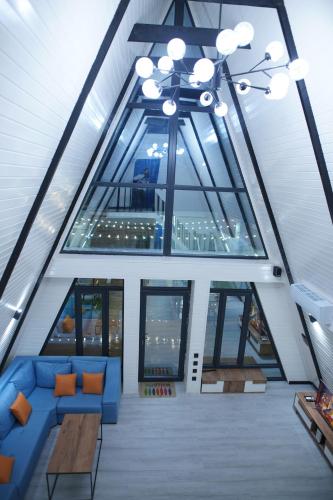 a room with a blue couch and some windows at Aframezing Gabala in Gabala