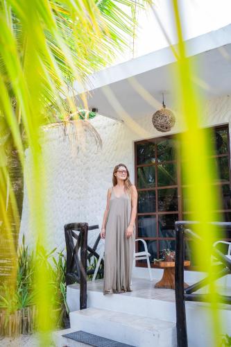 a woman standing on the stairs of a house at Sirenas Caribbean Rooms Holbox in Holbox Island
