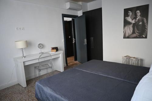 una camera con letto, scrivania e quadro di Haris 303 Apartment by VPN Accomodation ad Atene