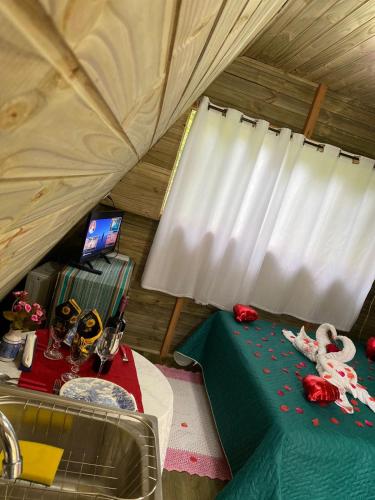 a room with a bed and a sink in a tent at Sítio flor da montanha in São Bento do Sapucaí