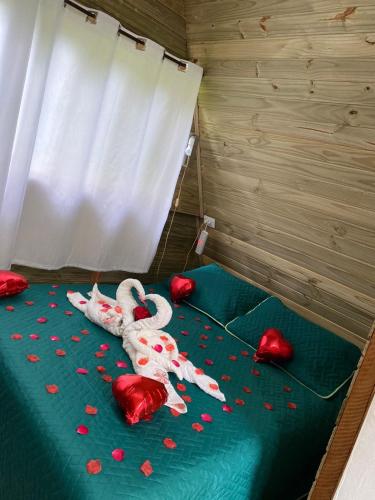 a room with a bed with red hearts on it at Sítio flor da montanha in São Bento do Sapucaí