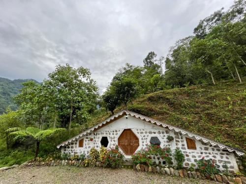 a small house with flowers on the side of a hill at Chumang River Nest in Thode