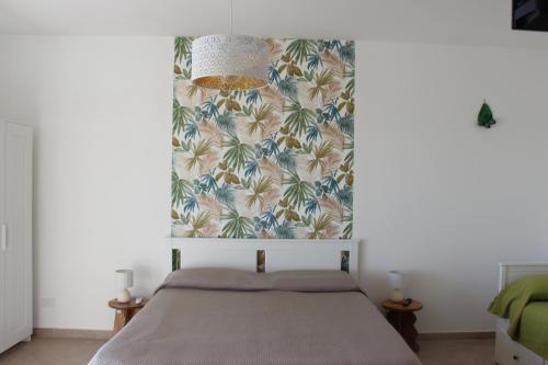 a bedroom with a bed with a tropical wallpaper at bariairport in Bari