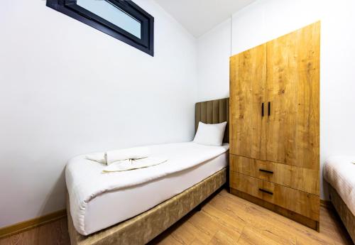 1 dormitorio con 1 cama y armario de madera en Mia Mia Suites en Estambul