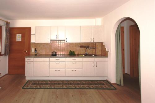a kitchen with white cabinets and a sink at Ferienwohnungen Auhaus in Martello