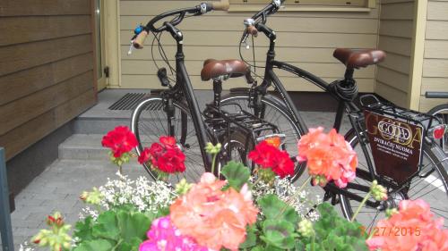 two bikes parked in front of a house with flowers at Goda Hotel & Spa in Druskininkai