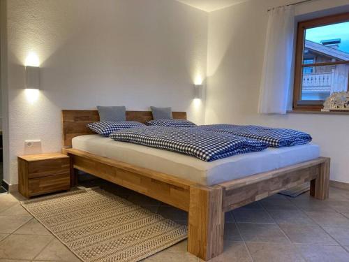 a bedroom with a wooden bed with blue pillows at Ferienwohnungen LARA Wohnung 2 in Wallgau