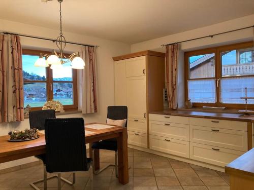 a kitchen with a wooden table and a dining room at Ferienwohnungen LARA Wohnung 2 in Wallgau