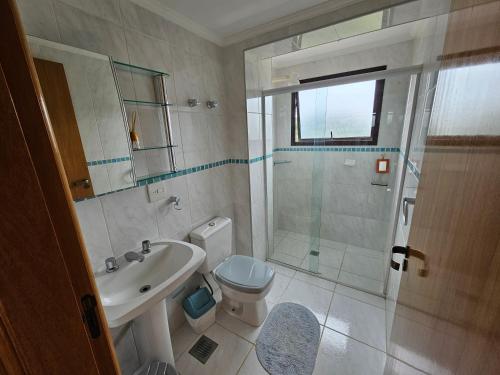 a bathroom with a toilet and a sink and a shower at Piemonte Flat in Serra Negra