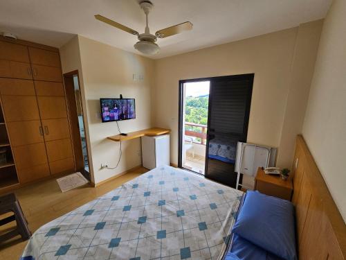 a bedroom with a bed and a window with a tv at Piemonte Flat in Serra Negra