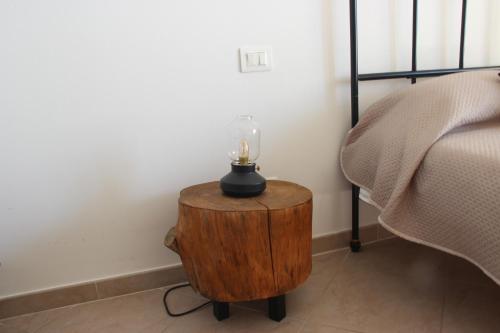 a table with a candle on it next to a bed at bariairport in Bari
