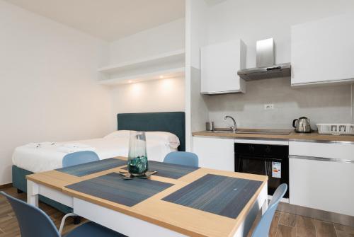 a room with a table and a kitchen with a bed at Aurelia Deluxe Suites in Rome