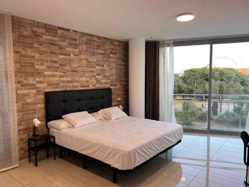 1 dormitorio con cama y pared de ladrillo en FIRA Gran Vía 2 - Private Rooms in a Shared Apartment - Habitaciones Privadas en Apartamento Compartido, en Hospitalet de Llobregat